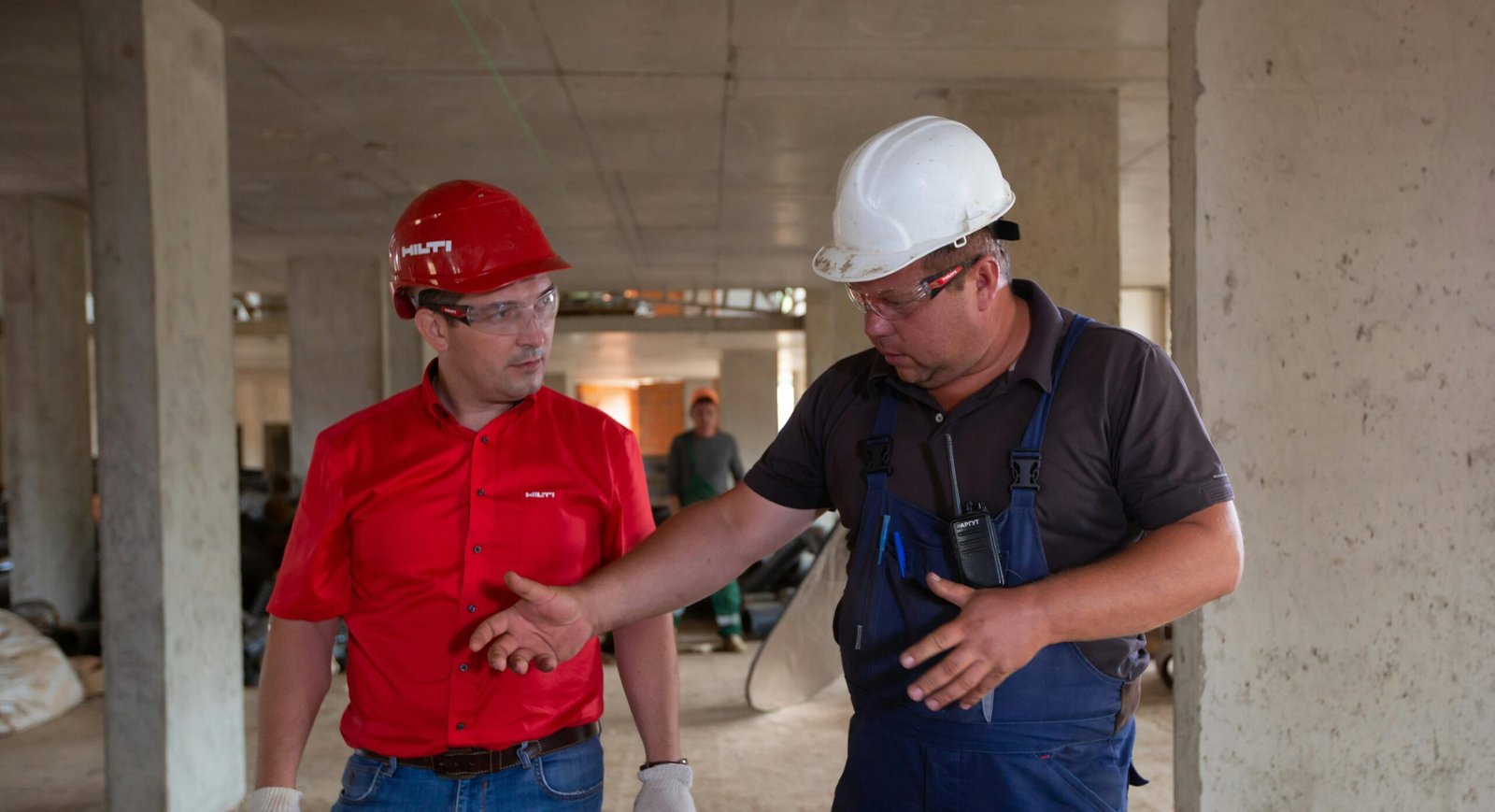 Twee mannen overleggen op een bouwplaats.